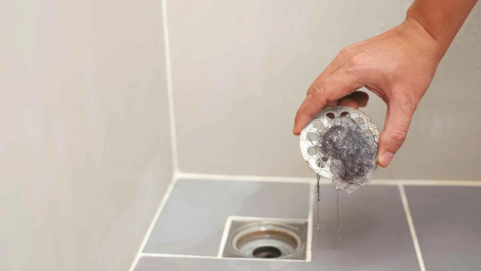 Haren en zeepresten worden uit een verstopt doucheputje verwijderd