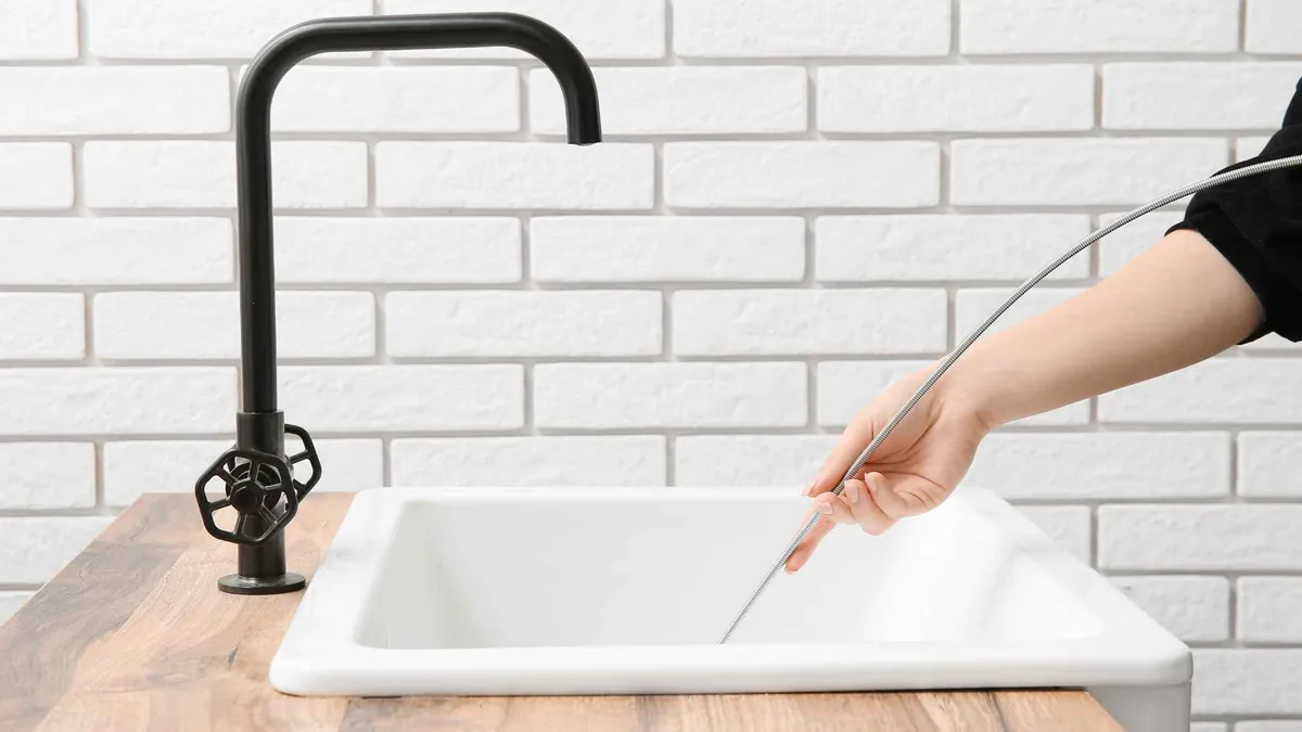 Flexibele sonde wordt in een keukenafvoer gevoerd voor inspectie